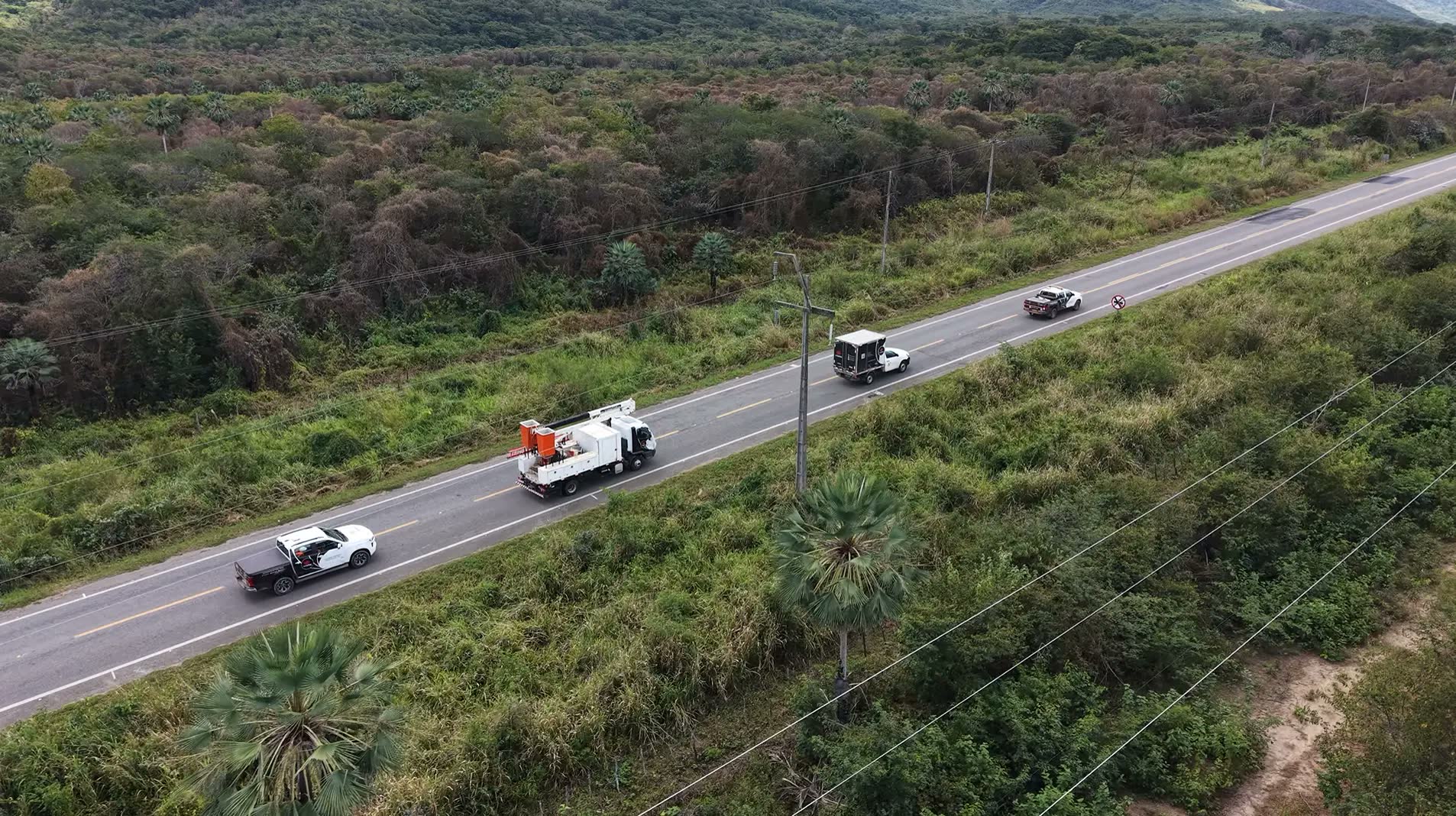 Comboio da Redeprime em rodovia: viaturas e caminhão com cesto aéreo